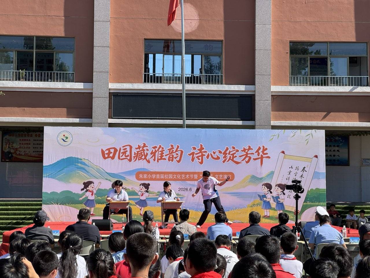 Directing children in a poetry performance on stage at Zhujia Primary School's campus arts festival