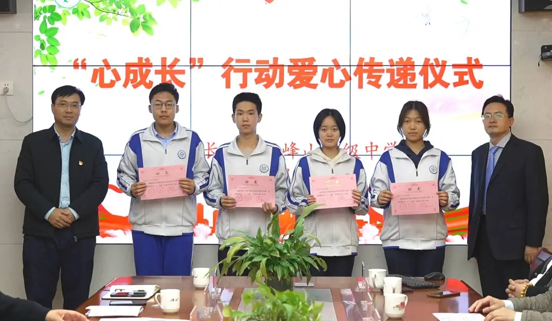 Four Wufengshan pupils holding certificates at the “Heart Growth” action love-transfer ceremony