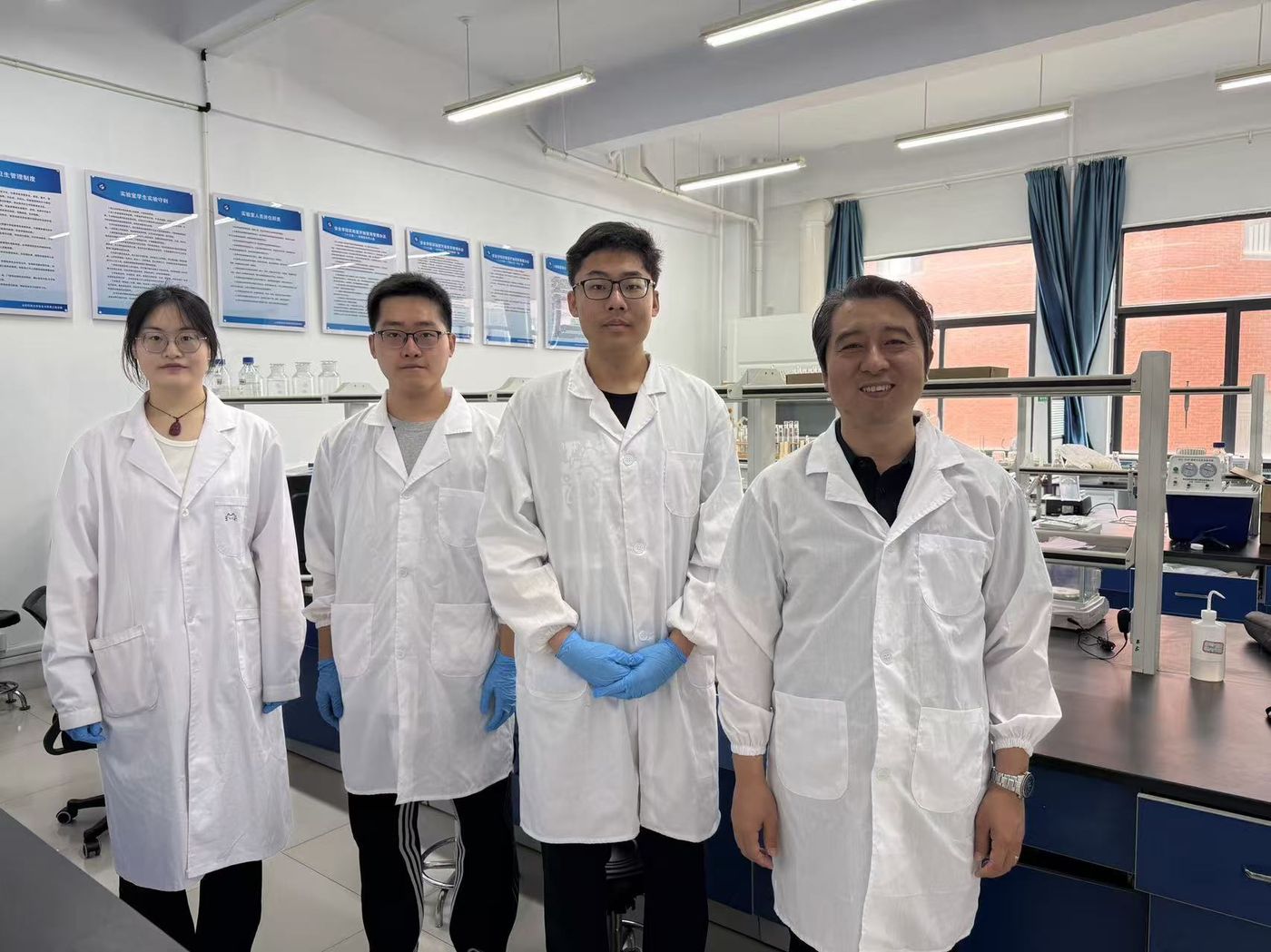 Ronghao Yang with Professor Cao's research team in lab coats